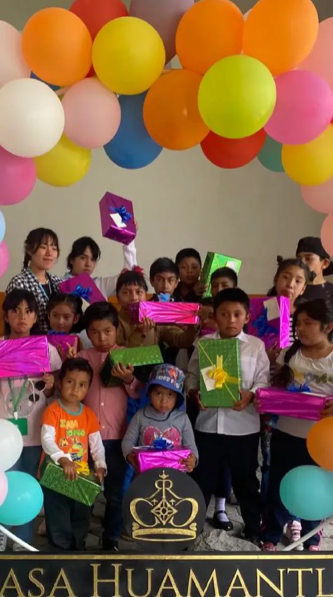 Niños con globos y regalos en evento comunitario